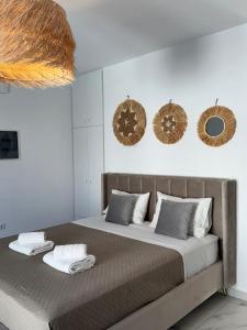 a bedroom with a large bed with two mirrors on the wall at Anemos Naxos town suites-apartment in Naxos Chora
