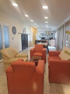 a living room with orange furniture and a kitchen at Palma de Mallorca 173 in Santa Clara del Mar
