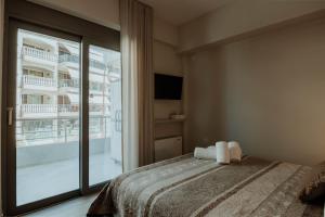 Un dormitorio con una cama y una ventana grande. en Dantis Place Alpha2, en Nauplia