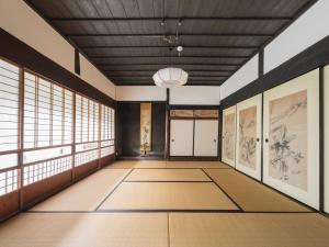 a room with a hallway with windows and paintings at 小川町 古民家田淵 -villa tabuchi- in Ogose