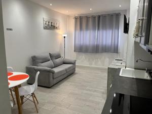 a living room with a couch and a table at Casita paraiso tenerife sur in Los Abrigos