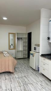 a room with a kitchen with a bed and a refrigerator at HolaCentro in General Roca +46 photos