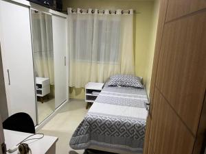 una piccola stanza con due letti e uno specchio di Casa em Anchieta completa próximo a castelhanos e Iriri a Anchieta