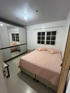 una camera da letto con un letto e due finestre di Casa em Anchieta completa próximo a castelhanos e Iriri a Anchieta