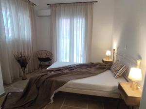 a bedroom with a large bed and a window at Rozas house in Benitses