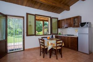 a kitchen with a table and some chairs in a room at Agriturismo Il Sughereto - Appartamento Cattleya in Podere Caminino