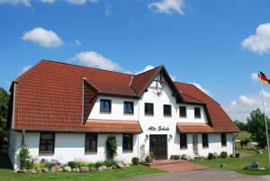 a white house with a red roof at FeWo Dänholm Alte Schule Barlin Mecklenburg Pool in Dargun