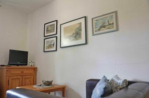 a living room with a couch and three pictures on the wall at FeWo Dänholm Alte Schule Barlin Mecklenburg Pool in Dargun
