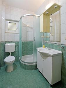 a bathroom with a toilet and a sink and a shower at Apartments Mićić in Hvar