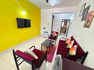 a living room with two red couches and a tv at Muffy’s Vacation Apartment in Baga