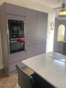 a kitchen with a table and an oven at Riverside Retreat Sleeps 7 in Cononley