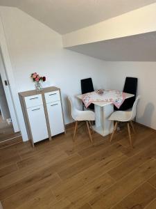 a dining room with a table and four chairs at Ferienwohnung Waldblick, Faaker See in Oberaichwald