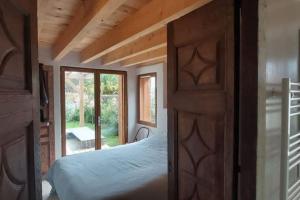 a bedroom with a wooden door with a bed in it at Villa de 95m Jardin et Terrasse in Anglet