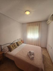 een slaapkamer met een bed met twee handdoeken erop bij Bungalow Brisa de Mar in Torrevieja