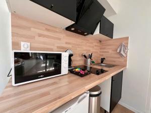 a kitchen counter with a microwave and a sink at Appartement 2 prsn Au cœur du Centre-Ville in Besançon +3 photos