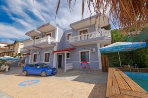 une maison avec une voiture bleue garée devant dans l'établissement Joen Apartment 2, à Saranda