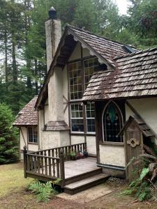 a small house with a porch and a large window at The Storybook Cottage in Mendocino