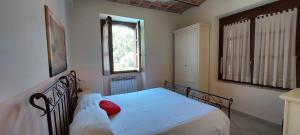 a bedroom with a bed with a red pillow on it at Le Rondini in Torricella