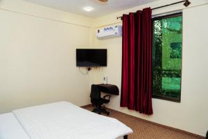 a bedroom with a bed and a television and a chair at Travel Nexus in Gilgit