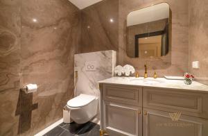 ein Badezimmer mit Toilette, Waschbecken und Spiegel in der Unterkunft The Western Hill Dalat Hotel in Da Lat + 43 Fotos