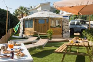 a yurt in a yard with a table with food at Yurta Glamping B&B San Leone Agrigento - tra mare e pineta in Agrigento