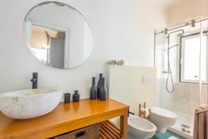 ein Badezimmer mit Waschbecken und Spiegel in der Unterkunft Charming Beach House - by Smarthomes in São Martinho do Porto + 30 Fotos