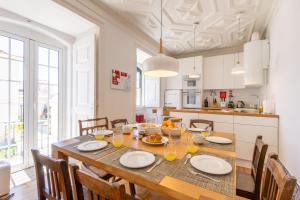 eine Küche und ein Esszimmer mit Tisch und Stühlen in der Unterkunft Charming Beach House - by Smarthomes in São Martinho do Porto