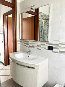 a bathroom with a white sink and a mirror at Casa Lucia in Lignano Sabbiadoro