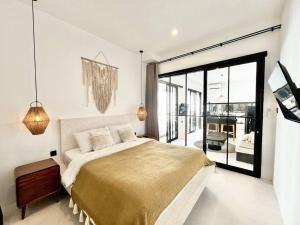 a bedroom with a large bed and a large window at 2BR Villa The Three Cactuses Stylish Mediteranian 5mins to Sanur Beach in Sanur