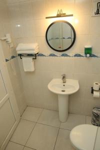 a white bathroom with a sink and a mirror at Ege Premium Hotel in Afyon +8 photos