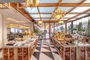 ein Esszimmer mit großen Tischen und Kronleuchtern in der Unterkunft The Western Hill Dalat Hotel in Da Lat