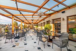 ein Restaurant mit Tischen und Stühlen auf einer Terrasse in der Unterkunft The Western Hill Dalat Hotel in Da Lat