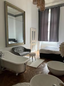 Un baño con bañera, cama y espejo. en Appartement au Palais - WIFI, en Moulins