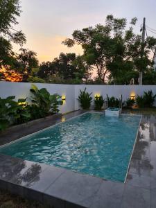 a swimming pool in front of a white fence at The Oasis Kuantan with Private Pool in Kuantan