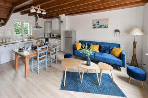 a living room with a blue couch and a table at L'Ecrin Marin - Plage Etretat in Étretat