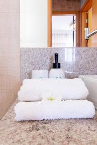 a pile of towels on a counter in a bathroom at PALMAS EXPERIENCE - APARTAMENTO CONTEMPORÂNEO, vista serra, na quadra do shopping in Palmas