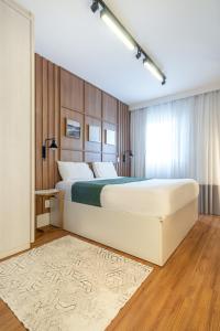 a bedroom with a large white bed and a rug at PALMAS EXPERIENCE - APARTAMENTO CONTEMPORÂNEO, vista serra, na quadra do shopping in Palmas