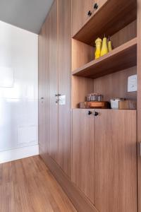 a kitchen with wooden cabinets and wooden floors at PALMAS EXPERIENCE - APARTAMENTO CONTEMPORÂNEO, vista serra, na quadra do shopping in Palmas