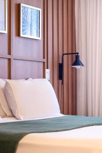 a bedroom with a bed and a lamp at PALMAS EXPERIENCE - APARTAMENTO CONTEMPORÂNEO, vista serra, na quadra do shopping in Palmas