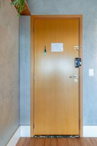 a wooden door in a room with a sign on it at PALMAS EXPERIENCE - APARTAMENTO CONTEMPORÂNEO, vista serra, na quadra do shopping in Palmas