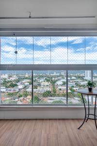 a room with a large window with views of a city at PALMAS EXPERIENCE - APARTAMENTO CONTEMPORÂNEO, vista serra, na quadra do shopping in Palmas