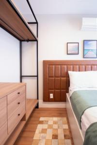 a bedroom with a large bed and a dresser at PALMAS EXPERIENCE - APARTAMENTO CONTEMPORÂNEO, vista serra, na quadra do shopping in Palmas