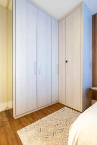 a bedroom with white cabinets and a bed and a rug at PALMAS EXPERIENCE - APARTAMENTO CONTEMPORÂNEO, vista serra, na quadra do shopping in Palmas