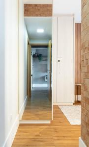 a hallway with white walls and wood floors at PALMAS EXPERIENCE - APARTAMENTO CONTEMPORÂNEO, vista serra, na quadra do shopping in Palmas
