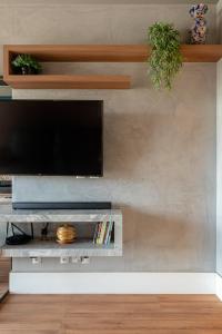 a living room with a flat screen tv on a wall at PALMAS EXPERIENCE - APARTAMENTO CONTEMPORÂNEO, vista serra, na quadra do shopping in Palmas