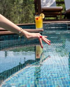 a woman with red nails and a drink in a swimming pool at Pastel Sapanca in Sapanca +54 photos