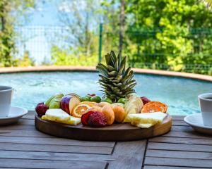 a plate of fruit on a wooden table next to a pool at Pastel Sapanca in Sapanca