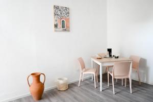a dining room with a table and chairs and a vase at Fatata Suites in Lecce