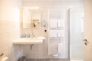 a white bathroom with a sink and a shower at Apartment Wasenberg in Willingshausen +15 photos