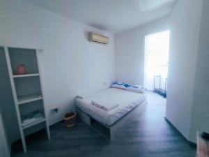 ein kleines Schlafzimmer mit einem Bett und einem Fenster in der Unterkunft Apartamento Las Mercedes - Playa in Torremolinos + 50 Fotos